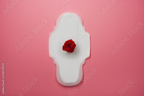 Menstrual pad with red rose on pink background