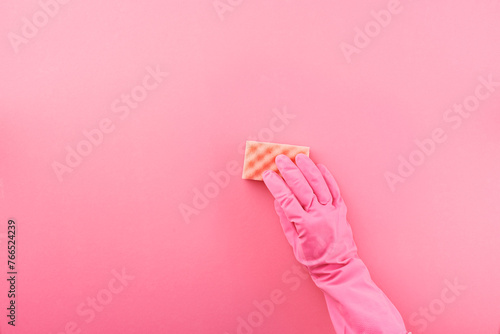 Hand in pink glove holding cleaning sponge
