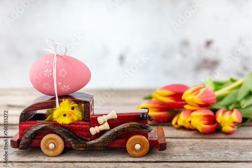 Toy car with an Easter egg and tulips