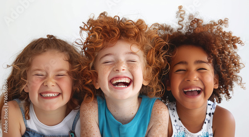  Close up portrait of 3 young children  happily laughing .  Concept of  friendship, happy childhood, fun.

