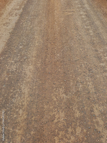 Dirt and gravel background. Unpaved road. Cracked and abrupt terrain. Dryness and climate change.