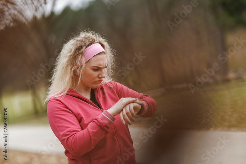 Woman Checking Fitness Tracker During Workout in a Park
