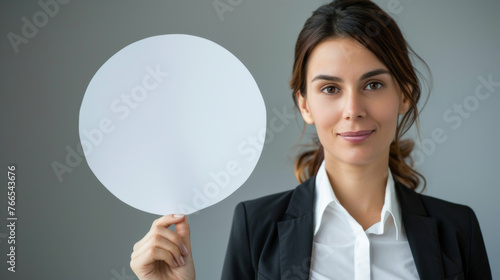 Porträt mit Nachrichtenkonzept. Eine junge Geschäftsfrau im Anzug hält eine leere Sprechblase aus Papier in Ihrer Hand.