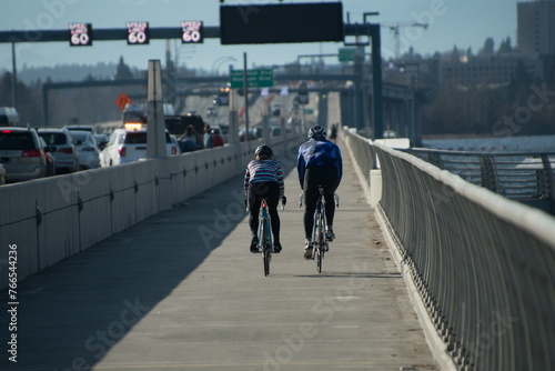 A couple of bicyclists ride from Eastside to Seattle on Evergreen Floating Bridge trail