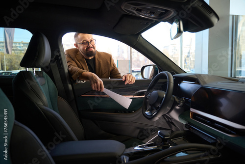 Young man inspects the interior of a new car © Viacheslav Yakobchuk