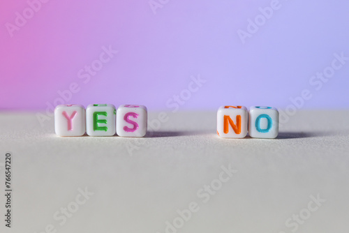 Colourful plastic letter cubes with Yes and No on gradient background concept photo