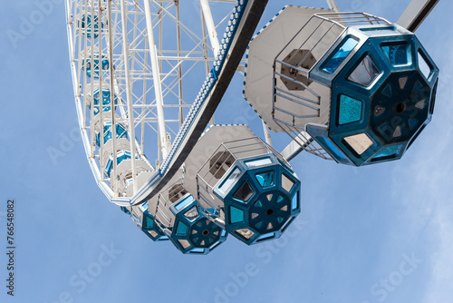 The pods of the Ferris wheel fly in the sky