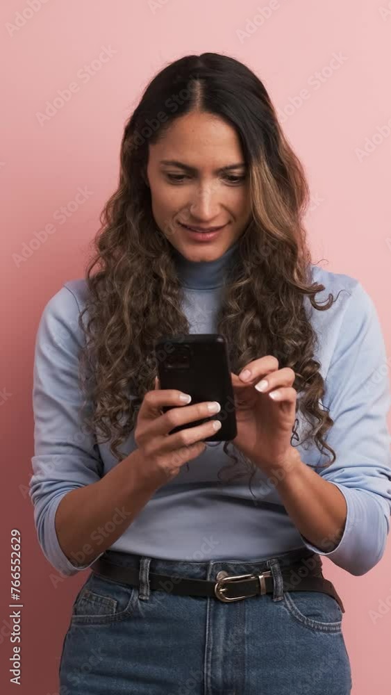 Smiling adult hispanic woman using mobile phone. Vertical footage Smiling adult hispanic woman using mobile phone. Vertical footage