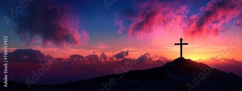 A silhouette of the cross on top of Mount Josef with a colorful sky in the background photo