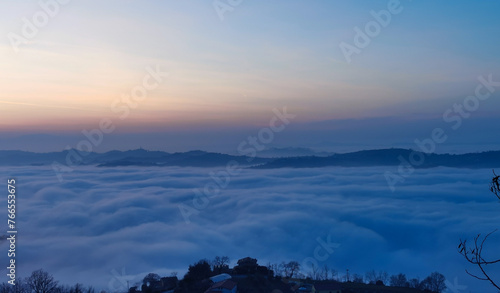 Un mare di nuvole bianche e di nebbia riempie le valli sotto le montagneal tramonto 