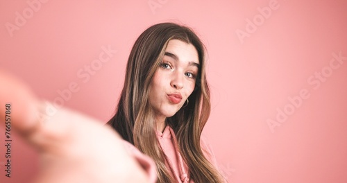 Pretty woman puckering lips in pink studio
