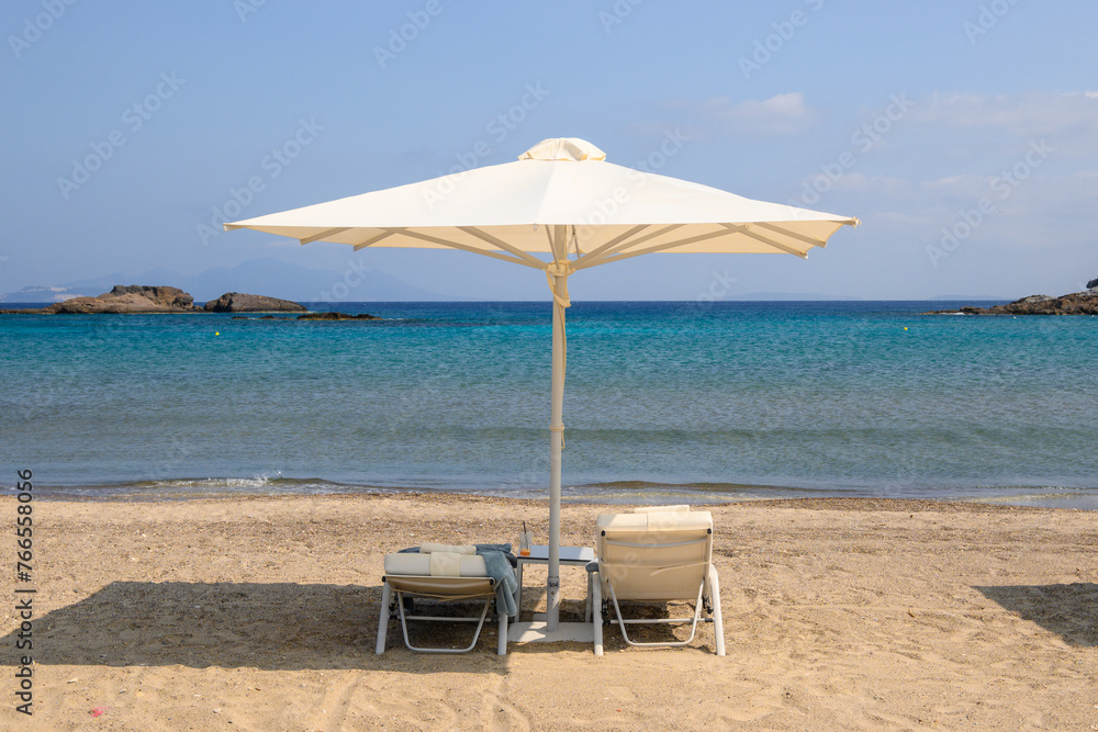 Sunbeds with umbrella on sandy beach of Agios Stefanos. The Greek island of Kos