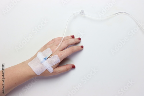 Woman’s hand with peripheral catheter in the left side in a white background with copy space in the right