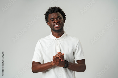Smiling African Man in White Shirt against gray background
