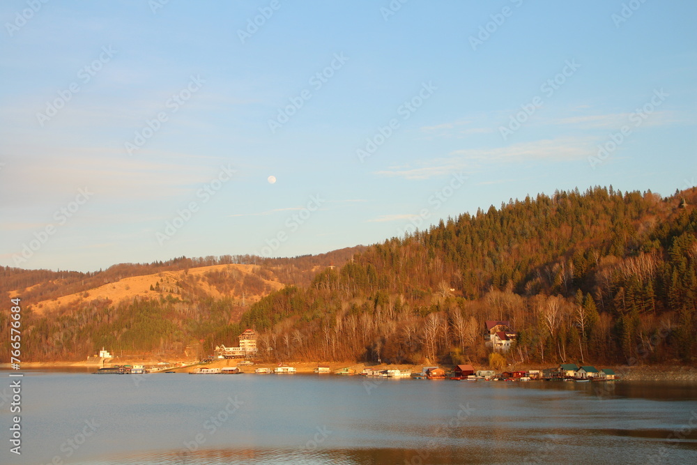 A body of water with trees and a hill in the background