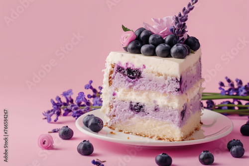 A slice of blueberry and lavender cheesecake cake on pink background with copy space.