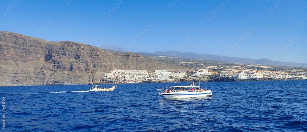sailing at sea with a catamaran towards the collosal rocks of Los Gigantos in Tenerife