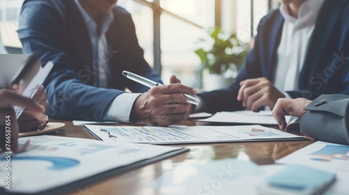 Close-up of business hands drawing and constructing graphs and plans at formal meeting or conference discussion. Teamwork, professionalism, and strategic planning in a formal business setting. photo