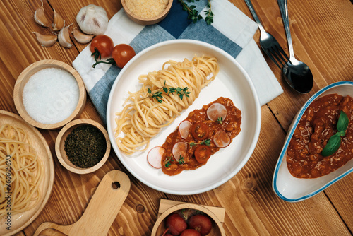 Delicious food's special menu homemade preparing station spaghetti with minced meat top tomato sauce and basil shooting placing elements serving with chef table surround decorative spices. Postulate.