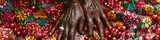 Close up view of hands of a person placed on a vibrant and colorful cloth, showing details and textures