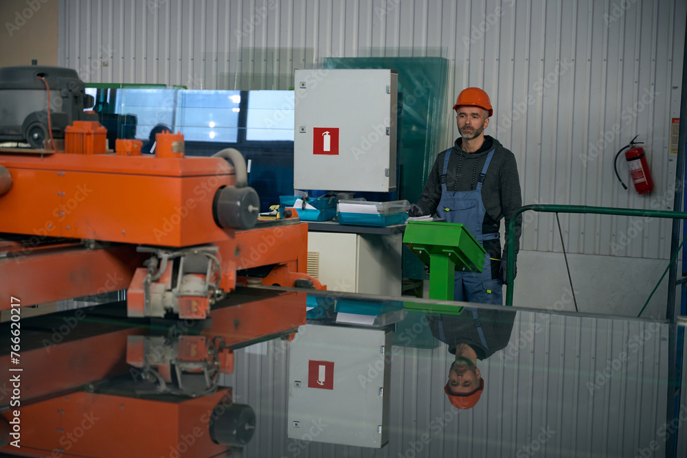 Specialist uses automatic table for cutting glass in window production