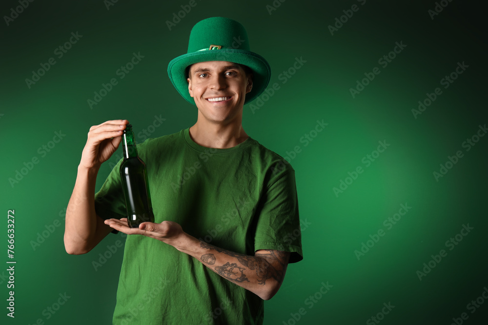 Young man with bottle of beer on dark green background. St. Patrick's Day Young man with bottle of beer on dark green background. St. Patrick's Day
