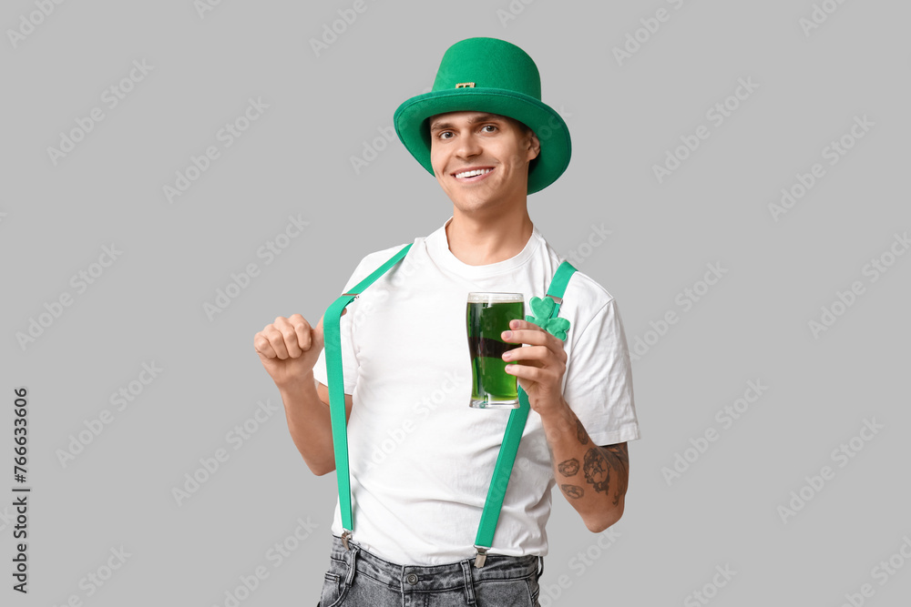Tattooed young man in leprechaun's hat and with glass of beer on light background. St. Patrick's Day Tattooed young man in leprechaun's hat and with glass of beer on light background. St. Patrick's Day