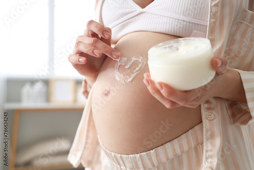 Pregnant woman applying moi...