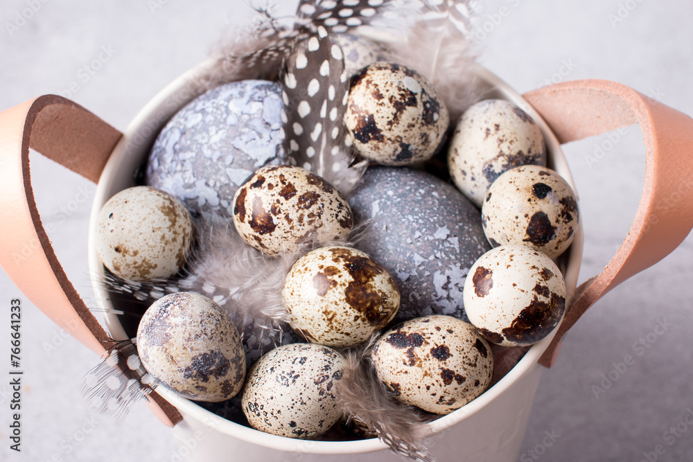 a plate with fluffy feathers and Easter quail eggs. Easter Holiday a plate with fluffy feathers and Easter quail eggs. Easter Holiday