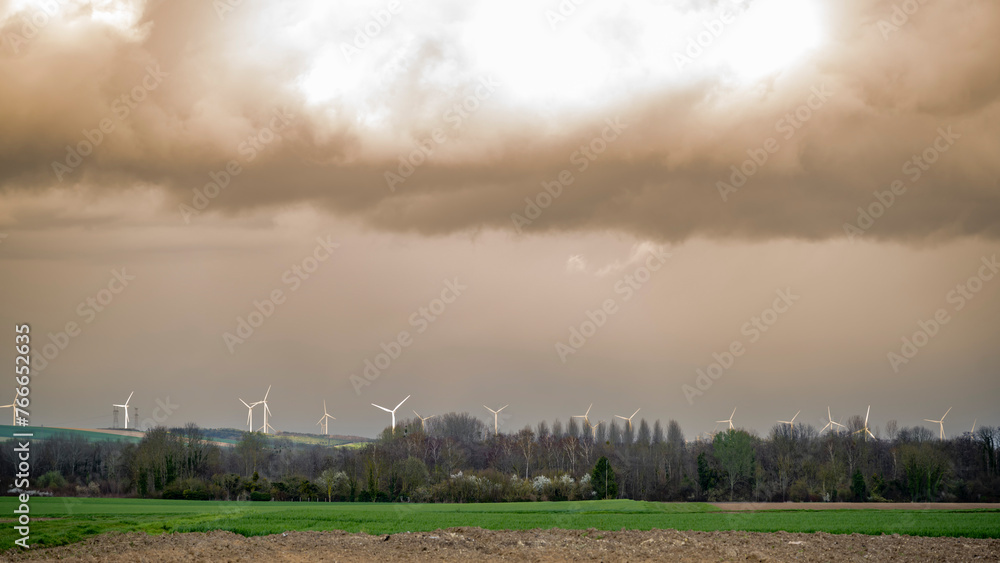horizon avec forêt et éolienne sur un ciel chargé de sable du sahara horizon avec forêt et éolienne sur un ciel chargé de sable du sahara