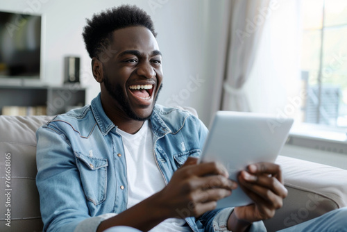 Happy young man with tablet on Sofa.