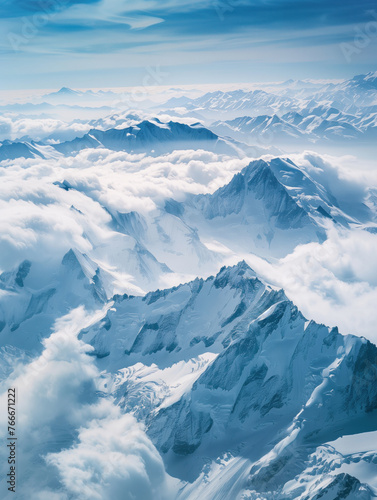 Snow covered mountains scenery. Snowy mountains in the clouds landscape. The sky is filled with clouds and the mountains are covered in snow. Concept of serenity and tranquility © Mrt