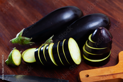 Sliced aubergine on wooden table, vegetable ingredients for cooking