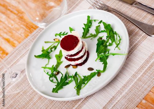 Salad with pieces of goat cheese, boiled beets and arugula
