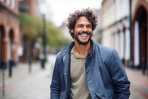 Portrait of a handsome young man with curly hair smiling at the camera