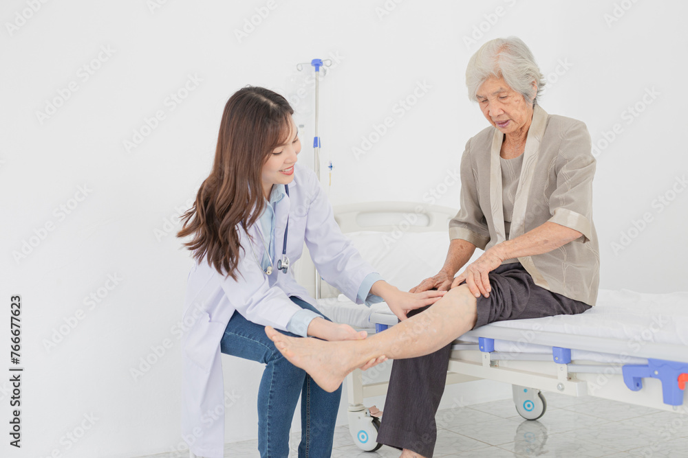 Obraz premium Asian female doctor holding leg of old stroke patient, they training to rehab muscle in hospital, Knee Replacement, Osteoarthritis of the Knee, elderly rehabilitation clinic