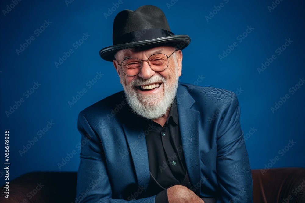 Portrait of a happy senior man with hat and glasses. Isolated on blue background. Portrait of a happy senior man with hat and glasses. Isolated on blue background.