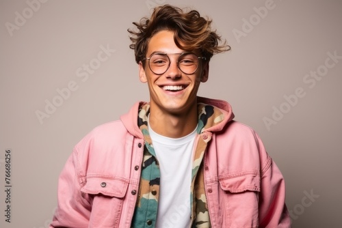 Portrait of a handsome young man with glasses and a pink jacket photo