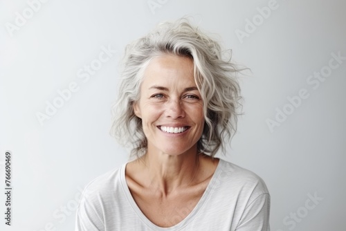 Portrait of a beautiful senior woman smiling at the camera with a white background