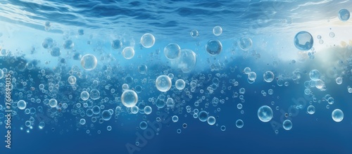 A multitude of bubbles drift in the azure liquid, creating a mesmerizing display of electric blue spheres against the watery font