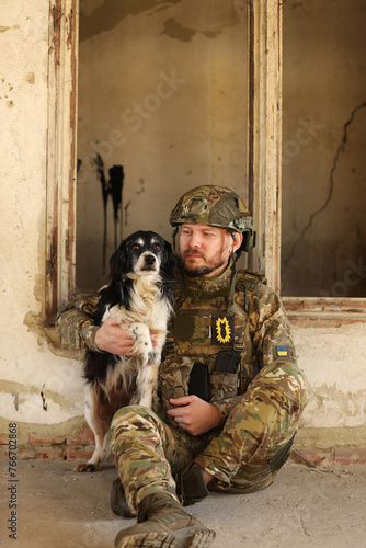 Ukrainian soldier sitting with stray dog in abandoned building © New Africa
