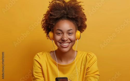 A woman with curly hair is wearing headphones and smiling