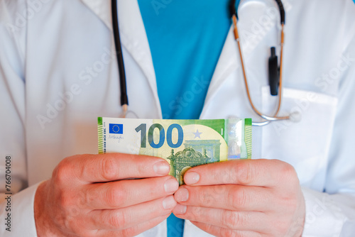 Paid medicine concept. doctor holds euro bills in his hand. Paid medical services.Payment for operations and medications.