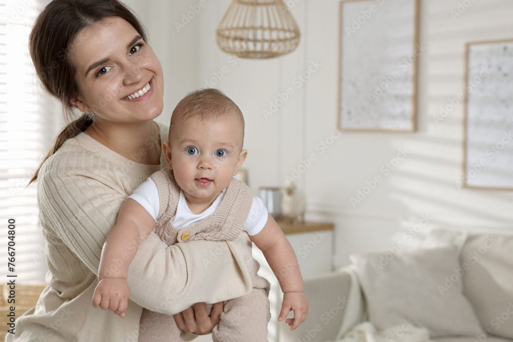 Happy young mother with her baby in living room. Space for text Happy young mother with her baby in living room. Space for text