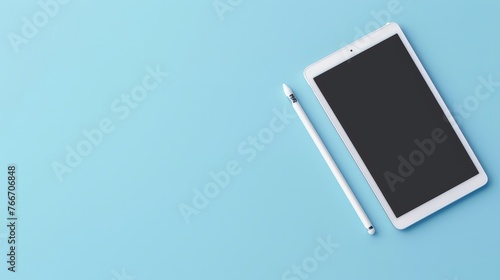 digital tablet and stylus pen on light blue background