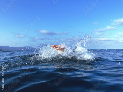 Diving in the sea with splashes and mountains in the background. Water splashes. Feets