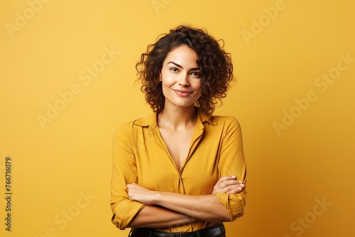 Portrait of a beautiful young woman with curly hair on yellow background