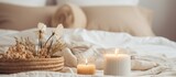 In the room, there are two candles placed on a hardwood nightstand and a wicker basket filled with dried flowers. The home accessories add a touch of rustic charm to the cozy ambiance