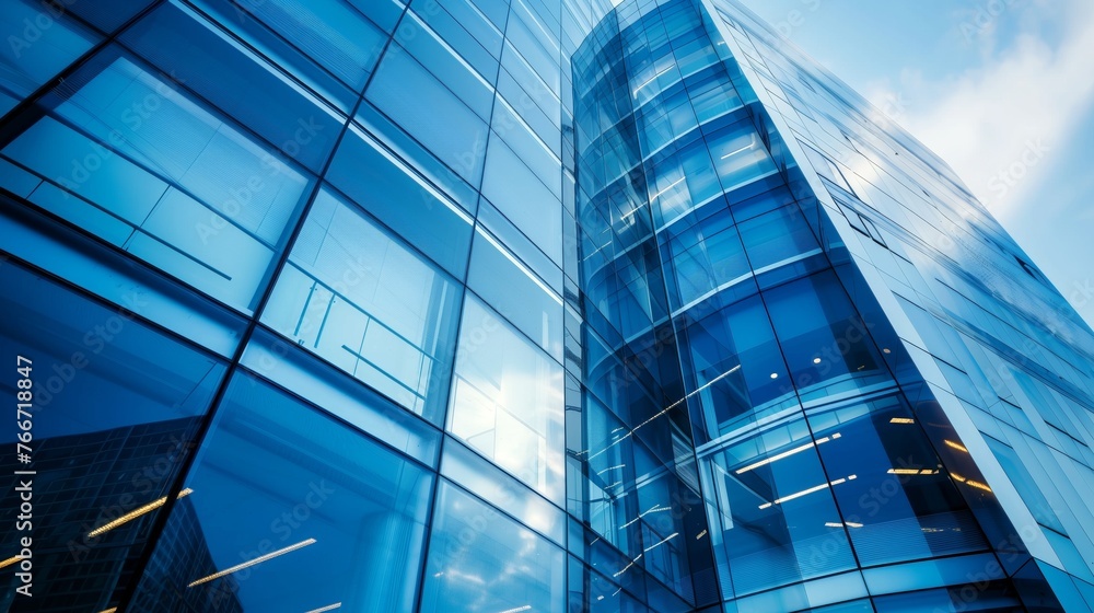 Obraz premium Blue sky reflecting on a curved glass skyscraper