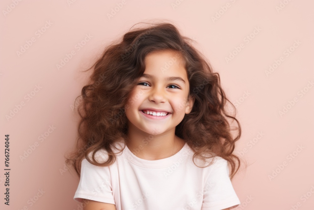 Portrait of a smiling little girl with long curly hair on a pink background Portrait of a smiling little girl with long curly hair on a pink background
